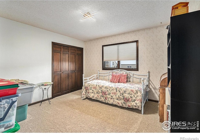 bedroom with light carpet and a textured ceiling