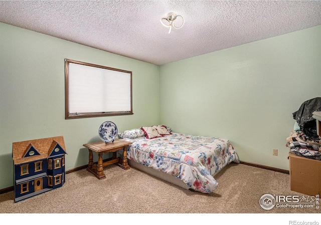 bedroom featuring light carpet and a textured ceiling