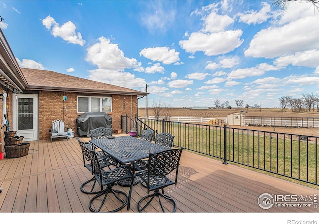 deck with area for grilling, a storage unit, and a lawn