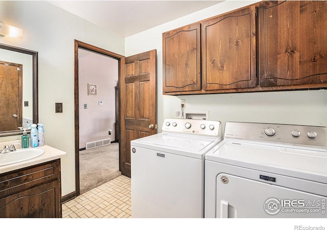 laundry room featuring cabinets, sink, light colored carpet, and washing machine and dryer