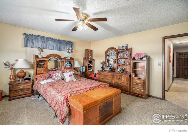 carpeted bedroom featuring a textured ceiling and ceiling fan