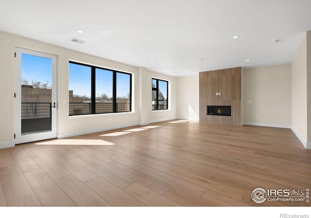 unfurnished living room with light hardwood / wood-style floors and a fireplace