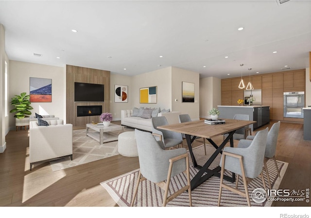 dining area featuring a fireplace and light hardwood / wood-style flooring