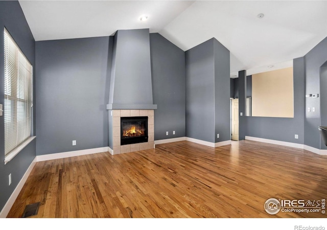 unfurnished living room with light hardwood / wood-style flooring and a tiled fireplace