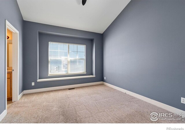 empty room with light carpet and vaulted ceiling