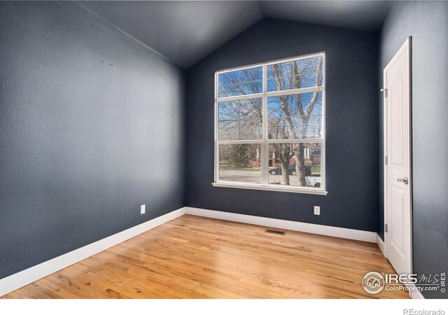 empty room with lofted ceiling and light wood-type flooring