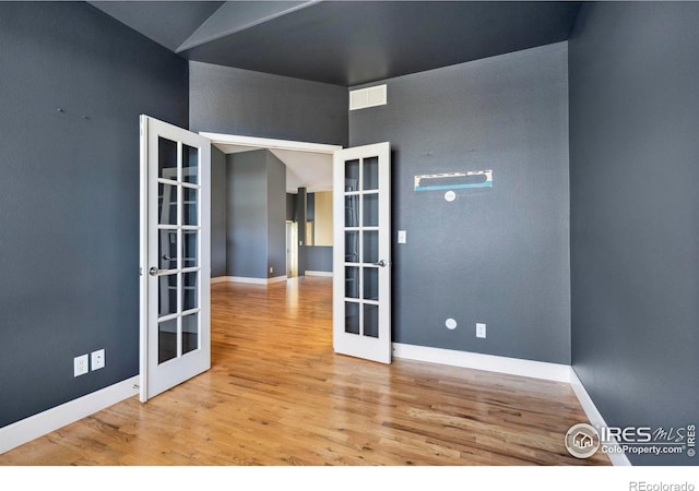 spare room with light hardwood / wood-style flooring and french doors