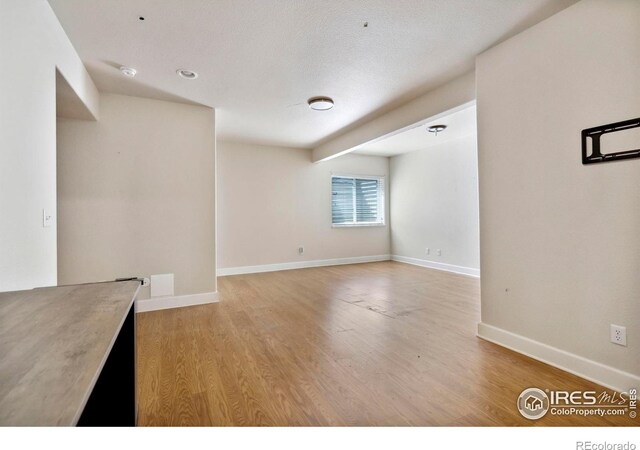 spare room featuring light hardwood / wood-style floors and a textured ceiling