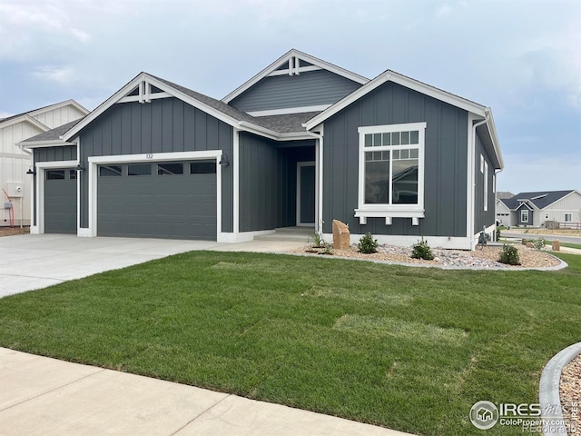 view of front of property with board and batten siding, a front lawn, a garage, and a shingled roof