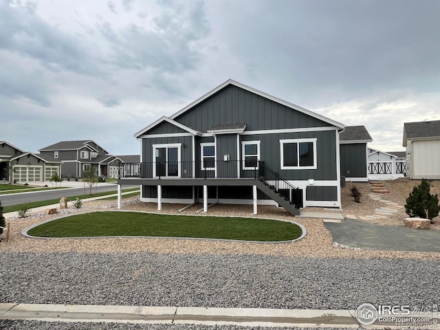 view of front of property featuring stairs, a front yard, and board and batten siding