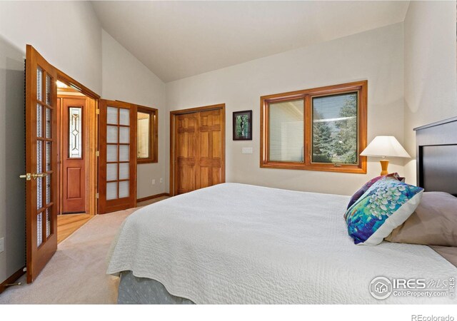 carpeted bedroom featuring a closet, french doors, and high vaulted ceiling