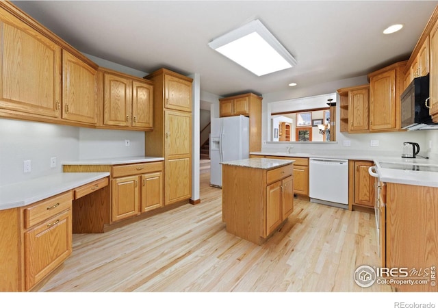 kitchen featuring a kitchen island, white appliances, light hardwood / wood-style floors, and sink