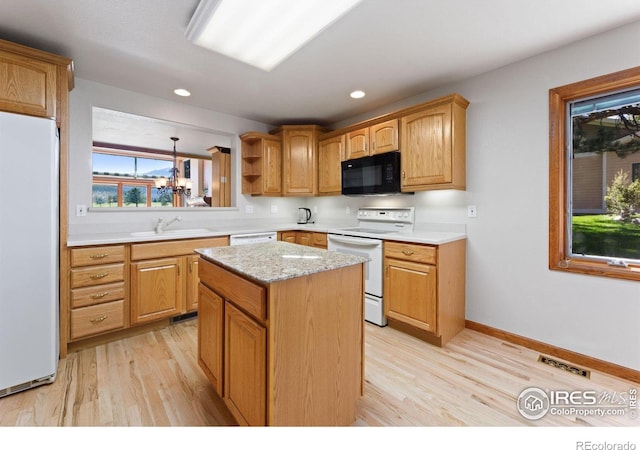 kitchen featuring a kitchen island, white appliances, sink, and light wood-type flooring