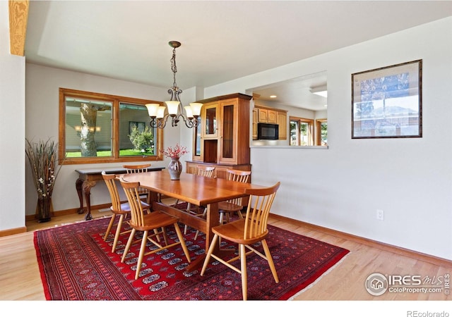 dining room with light hardwood / wood-style floors and an inviting chandelier