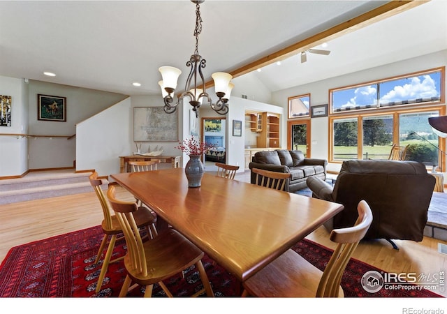 dining room with a notable chandelier, vaulted ceiling with beams, and light wood-type flooring