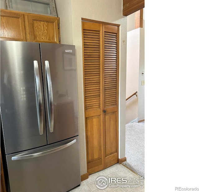 kitchen with light colored carpet and stainless steel fridge