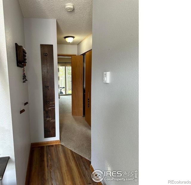 hall featuring hardwood / wood-style flooring and a textured ceiling