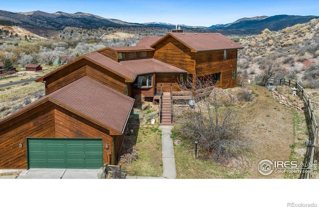 log-style house with a garage and a mountain view