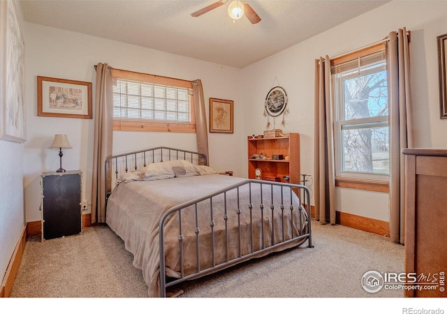 bedroom featuring light carpet, ceiling fan, and a textured ceiling