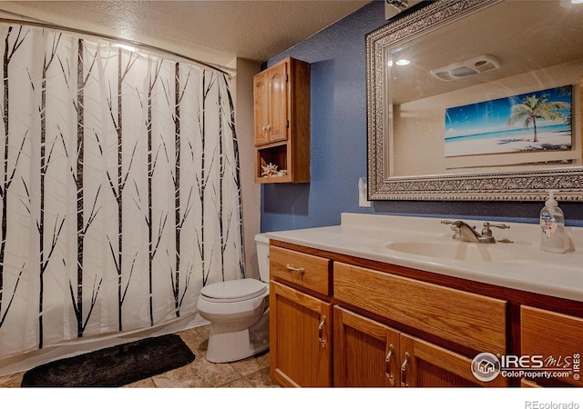 bathroom featuring toilet, vanity, curtained shower, and a textured ceiling