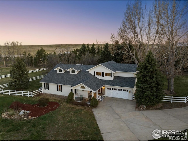 view of front of property featuring a garage and a lawn