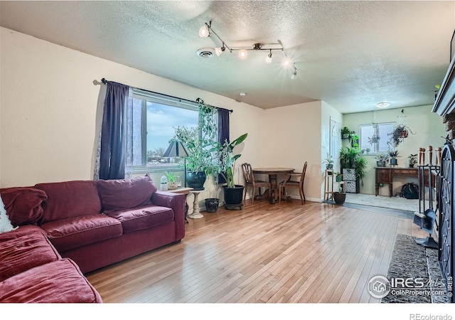 living room featuring light hardwood / wood-style floors and a textured ceiling