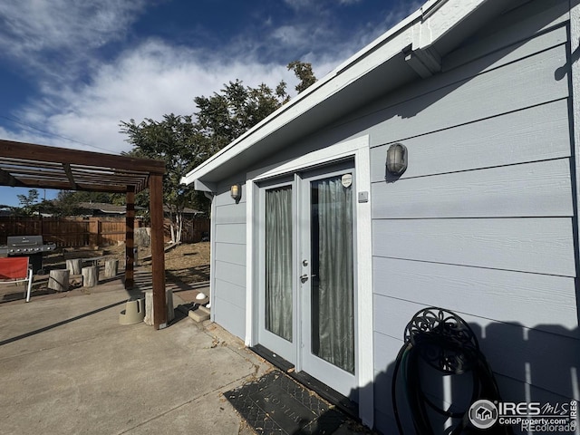 view of exterior entry featuring a pergola and a patio area