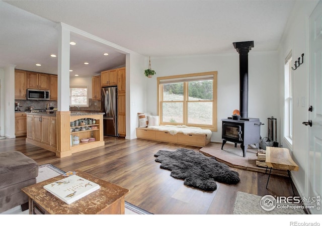 1553 Rowell Dr, Lyons, CO 80540 - living area with a wood stove, dark wood finished floors, crown molding, recessed lighting, and baseboards