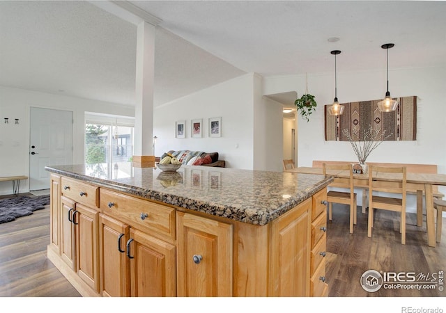 1553 Rowell Dr, Lyons, CO 80540 - kitchen featuring dark wood-style floors, dark stone counters, pendant lighting, a center island, and lofted ceiling