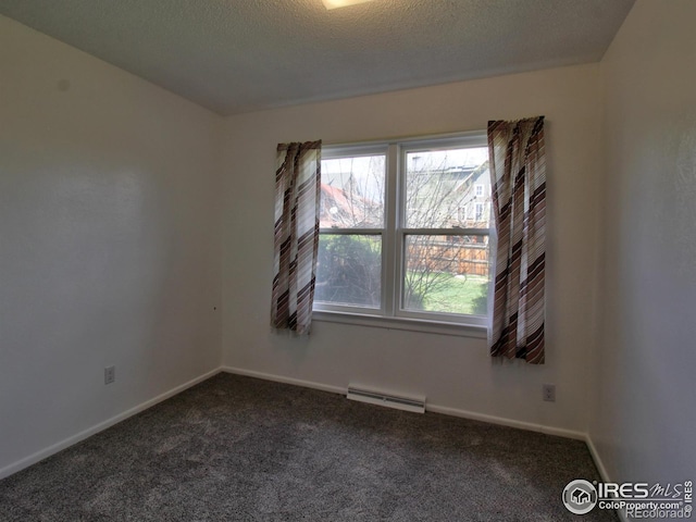 carpeted empty room with a baseboard radiator and a textured ceiling