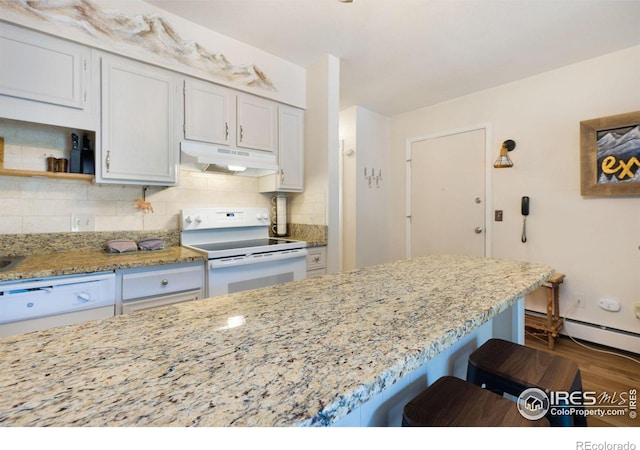 kitchen featuring a baseboard heating unit, backsplash, a breakfast bar area, white electric range, and light stone countertops