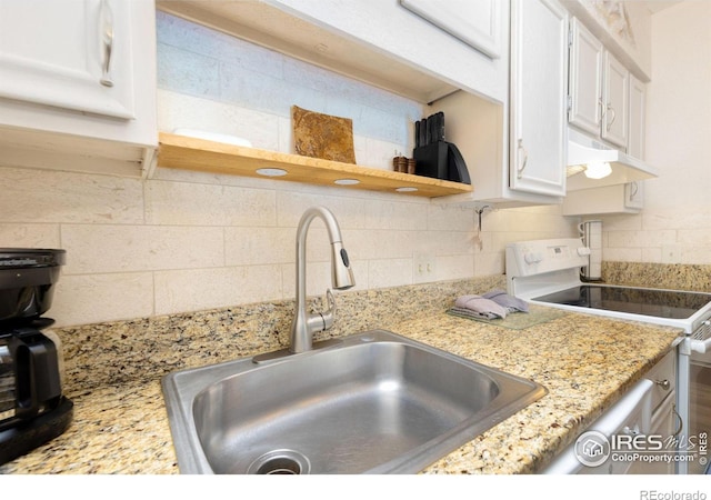 kitchen featuring white cabinets, sink, light stone counters, tasteful backsplash, and electric range