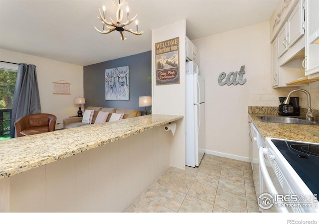 kitchen featuring white appliances, light tile flooring, white cabinets, sink, and an inviting chandelier