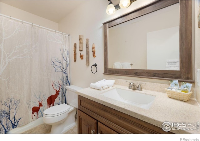 bathroom featuring tile floors, vanity, and toilet