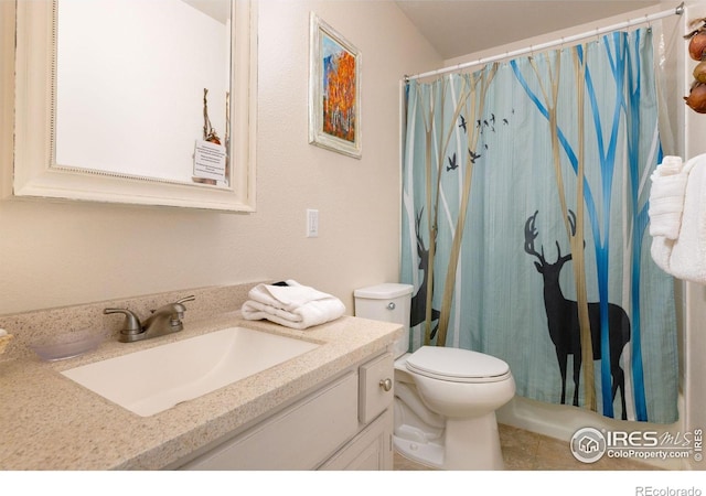 bathroom featuring tile floors, vanity, and toilet