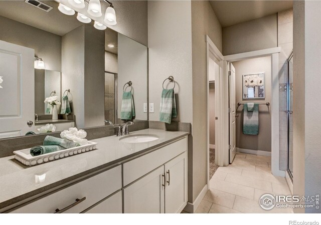 bathroom featuring vanity with extensive cabinet space, tile floors, and walk in shower