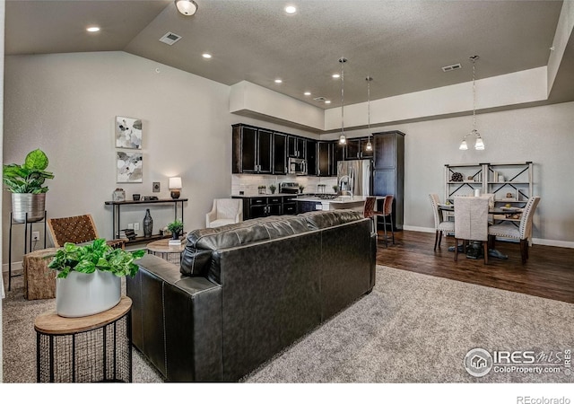 living room featuring lofted ceiling, dark hardwood / wood-style floors, and a chandelier