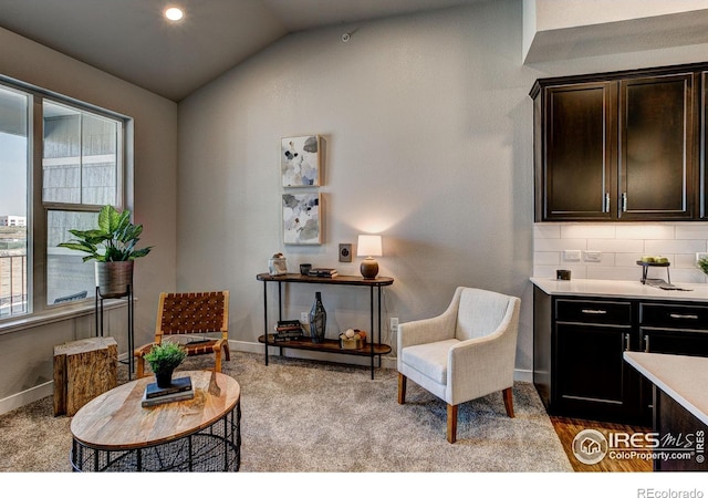 sitting room with light colored carpet and lofted ceiling