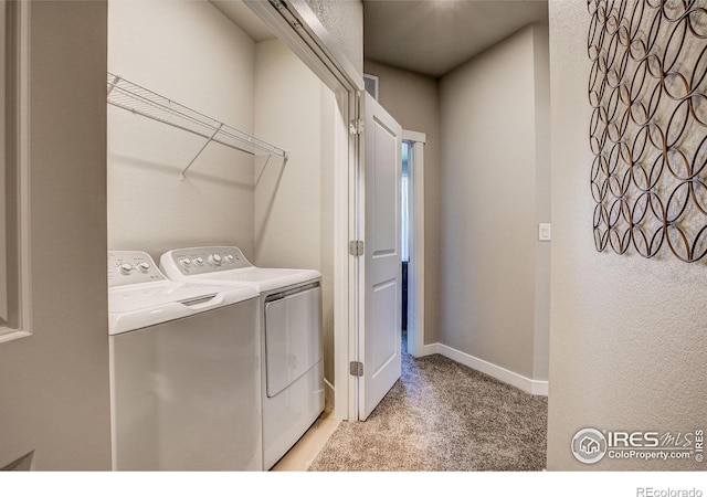 laundry room with washing machine and clothes dryer and light carpet