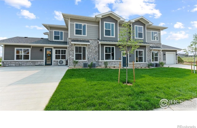 view of front of home with cooling unit, a garage, and a front lawn