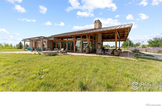 back of property featuring ceiling fan, a pergola, a lawn, and a patio area