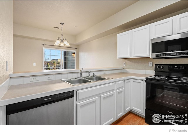 6925 19th St Unit 15, Greeley, CO 80634 - kitchen featuring stainless steel appliances, an inviting chandelier, white cabinets, sink, and light wood-type flooring