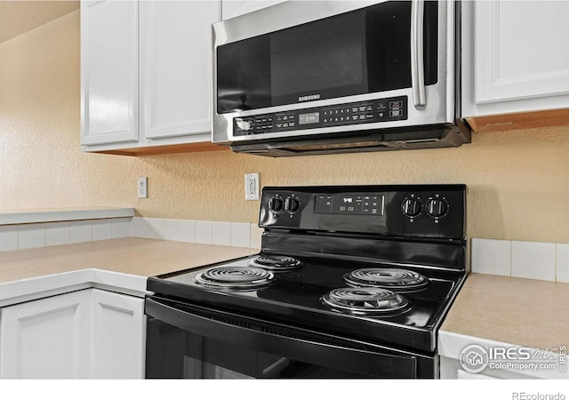 6925 19th St Unit 15, Greeley, CO 80634 - kitchen with black electric range and white cabinetry