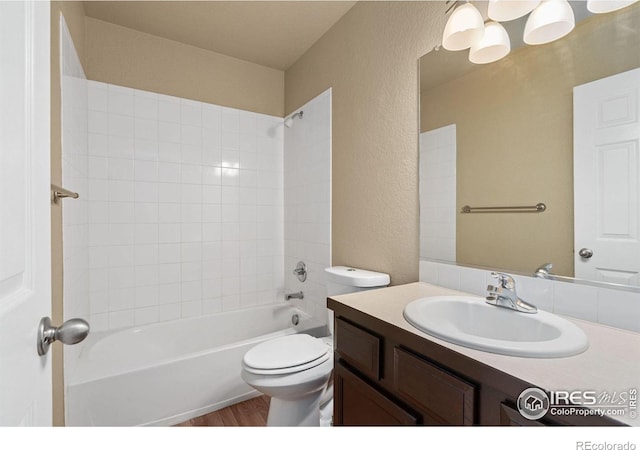6925 19th St Unit 15, Greeley, CO 80634 - full bathroom featuring wood-type flooring, tiled shower / bath, toilet, and large vanity