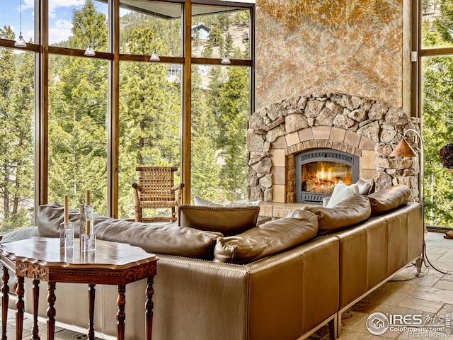 unfurnished sunroom with a stone fireplace