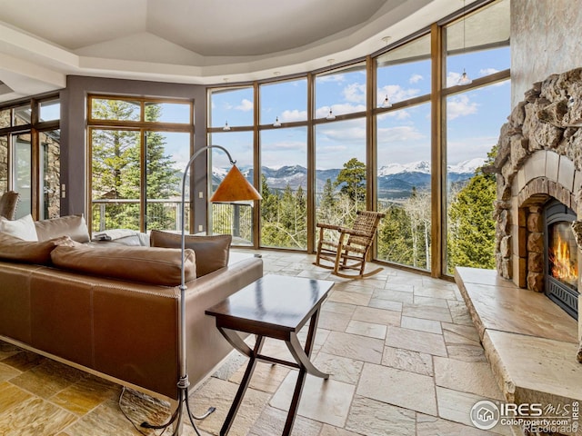 living room with a mountain view, a wall of windows, and a fireplace