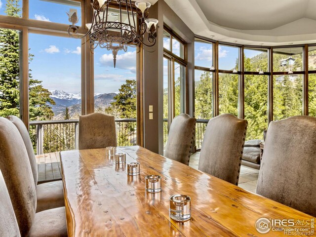 dining space featuring a mountain view, a chandelier, and expansive windows