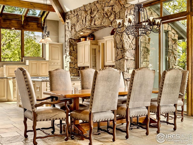 dining space featuring lofted ceiling with beams and an inviting chandelier