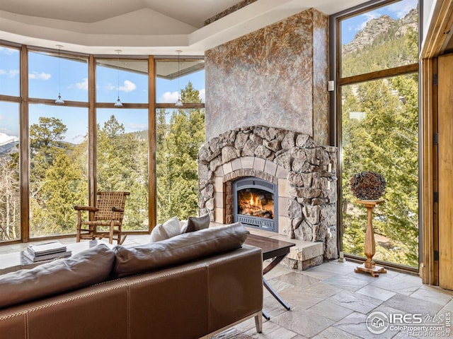 unfurnished living room with expansive windows and a stone fireplace