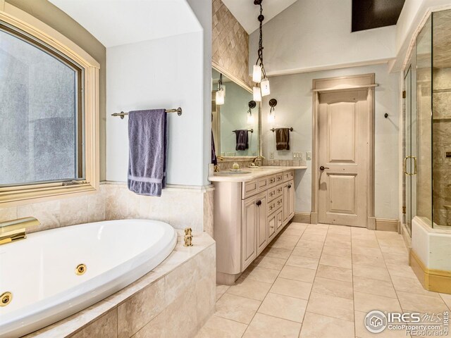 bathroom with tile patterned floors, independent shower and bath, and vanity